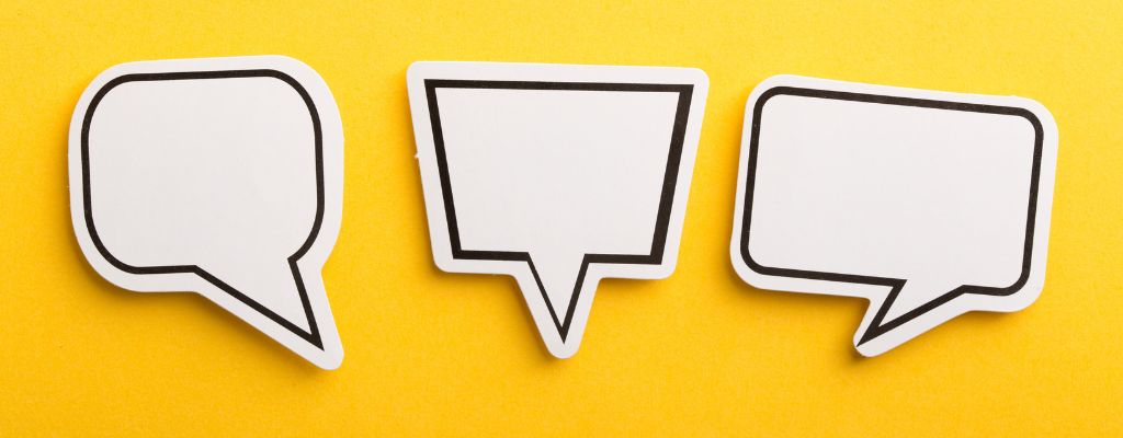 three white word bubbles on a yellow background