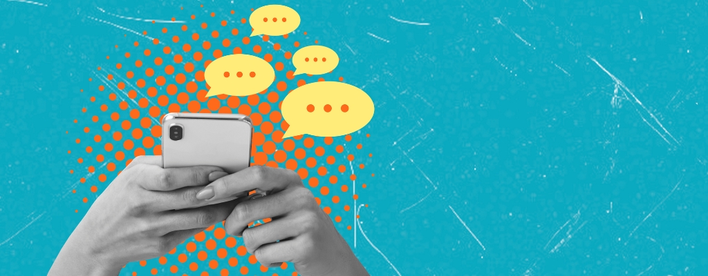 Grayscale hands holding a cell phone with yellow chat bubbles indicating nonprofit social media engagement